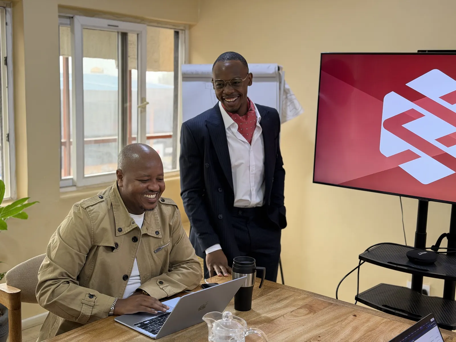 Twee senior collega's van Data XL in gesprek achter een laptop op het kantoor in Nairobi