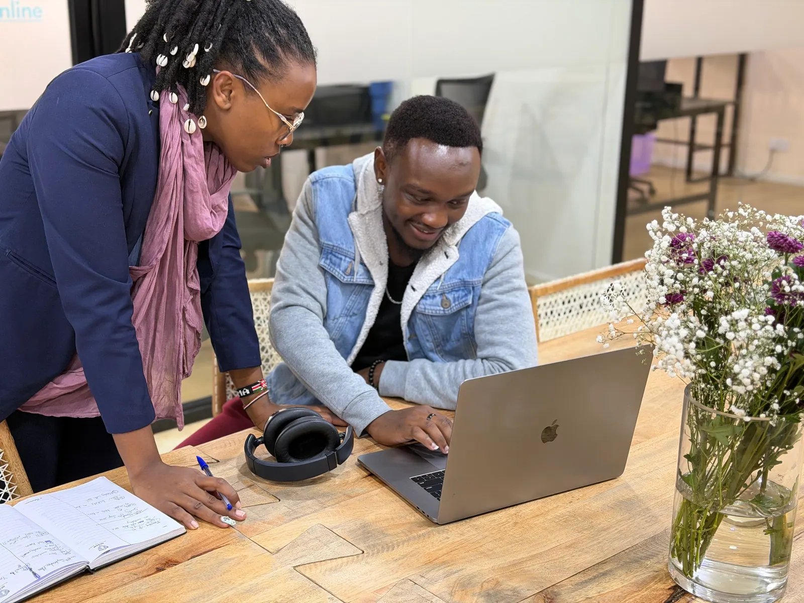 Twee collega's van Data XL werken samen aan een laptop in het kantoor in Nairobi